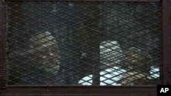 FILE - Members of Egypt's now banned Muslim Brotherhood are seen in detention in Cairo, Feb. 28, 2015.