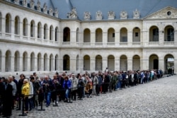 People queue to say a final farewell to former French President Jacques Chirac as the coffin lie in state at the Saint-Louis-des-Invalides cathedral at the Invalides memorial complex in central Paris, Sept. 29, 2019.