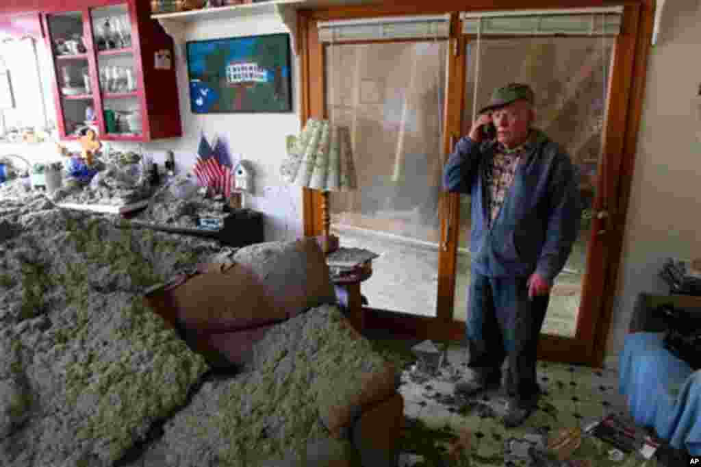 Blaine Lawson, 76, stands inside his house after a reported tornado tore the roof off his home, Friday, March 2, 2012, in Cleveland, Tenn. Neither he nor his wife were injured. (AP Photo/Robert Ray)