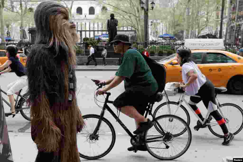 មនុស្ស​ម្នាក់​តែង​ខ្លួនដោយ​ស្លៀក​ពាក់​ជា​តួអង្គ&nbsp;Chewbacca ឈរ​នៅ​ក្បែរមហាវិថី​ទី​៦ ក្នុង​ពេល​គាត់​កំពុង​ផ្សព្វផ្សាយ​ខ្សែភាពយន្ត​មួយ​ដែល​នឹង​ដាក់បញ្ជាំង​នា​ពេល​ឆាប់ៗ​នេះ​ឈ្មោះ​ថា​&nbsp;Solo: A Star Wars Story នៅ​ទីក្រុង​&nbsp;Manhattan នៃបុរី​ញូវយ៉ក សហរដ្ឋ​អាមេរិក។