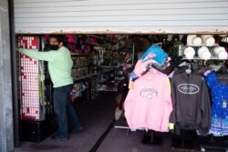 Mohammad Ikram closes a large door to his business Hot Stop, fully stocked but closed during the coronavirus pandemic, on the boardwalk in Atlantic City, N.J., April 28, 2020.