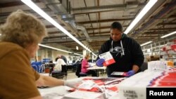 지난 3월 미국 워싱턴주 랜턴의 프라이머리(예비선거) 투표 개표소에서 선거 관리 관계자들이 우편투표 용지를 선별하고 있다. 