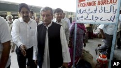 Pakistan's Railway Minister Haji Ghulam Ahmad Bilour, center, arrives at the Attari railway station on the Samjhauta Express train near Amritsar, India, May 19, 2011.