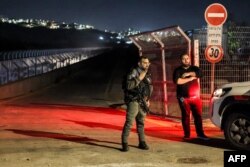 FILE - An Israeli border guard stands at the scene of a reported car-ramming attack at the Ras Bidu checkpoint near the Israeli settlement of Givat Zeev, between Jerusalem and Ramallah in the occupied West Bank, on January 7, 2024.