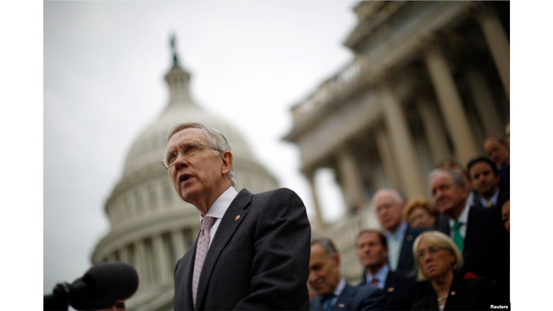 FILE - U.S. Senate Majority Leader Harry Reid, with other Democratic Party Senate members in the background, is seen on the steps of the U.S. Capitol in Washington, D.C.
