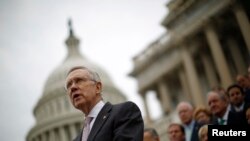 FILE - U.S. Senate Majority Leader Harry Reid, with other Democratic Party Senate members in the background, is seen on the steps of the U.S. Capitol in Washington, D.C..