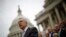 FILE - U.S. Senate Majority Leader Harry Reid, with other Democratic Party Senate members in the background, is seen on the steps of the U.S. Capitol in Washington, D.C..
