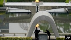 Wali Kota Hiroshima Kazumi Matsui (kanan) dan perwakilan keluarga keluarga korban bom atom di Monumen Peringatan Hiroshima, dalam upacara peringatan 75 Tahun pemboman Hiroshima, Kamis, 6 Agustus, 2020.