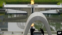 Kazumi Matsui, right, mayor of Hiroshima, and the family of the deceased bow before they place the victims list of the Atomic Bomb at Hiroshima Memorial Cenotaph during the ceremony to mark the 75th anniversary of the bombing at the Hiroshima Peace…