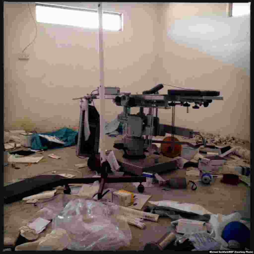 A vandalized operating table stands in Leer Hospital's surgical theater amid ransacked medical supplies. 