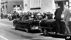 Xe chở nhân viên mật vụ chạy sau chiếc limousine chở Tổng thống Kennedy và phu nhân, trong thành phố Dallas, Texas, ngày 22/11/1963.
