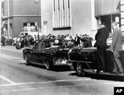 FILE - The presidential limousine carrying President John F. Kennedy and first lady Jacqueline Kennedy is followed by secret servicemen on running boards, Dallas, Texas, Nov. 22, 1963.