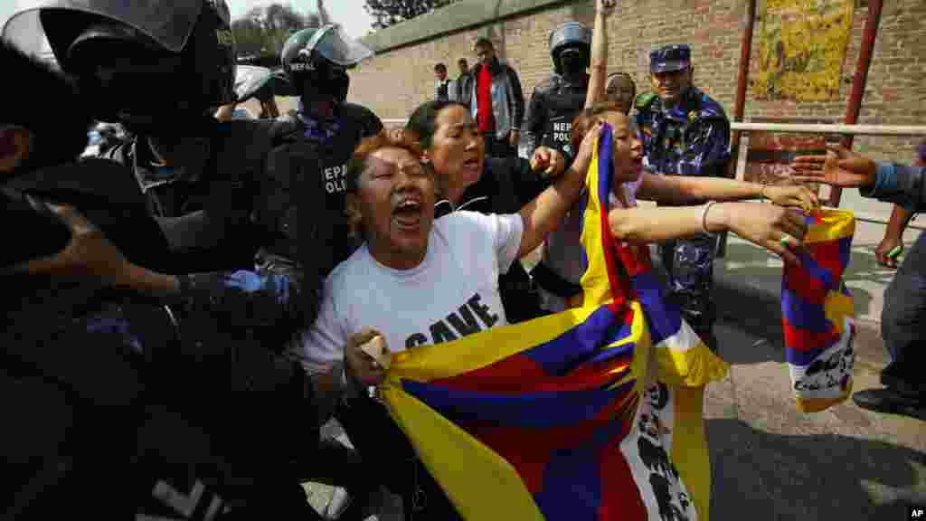 Nepalese policemen detain exiled Tibetans as they shout slogans during a protest outside the Chinese embassy visa office in Katmandu, Nepal (AP Photo/Niranjan Shrestha)