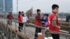 Members of environmental group The Carp Team encourage passing motorbike drivers on Long Bien Bridge not to drop plastic bags, Hanoi, February 12, 2014. (Marianne Brown for VOA News)