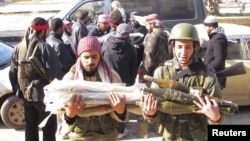 Free Syrian Army fighters transport ammunition which was seized from government forces' Wadi al-Daif military base at Maaret al-Numan, in the Idlib governorate in the northwest of Syria, December 29, 2012.