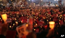 South Korean protesters hold candles during a rally calling for South Korean President Park Geun-hye to step down in Seoul, South Korea, Nov. 19, 2016. For the fourth straight Saturday, masses of South Koreans filled major avenues in downtown Seoul demanding an end to the Park presidency.