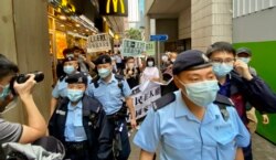 香港支联会及社民连4名成员4月15日首个国家安全教育日游行示威，被大批军装警员包围 （美国之音/汤惠芸）