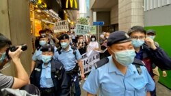 香港支聯會及社民連4名成員4月15日首個國家安全教育日遊行示威，被大批軍裝警員包圍 （美國之音湯惠芸）