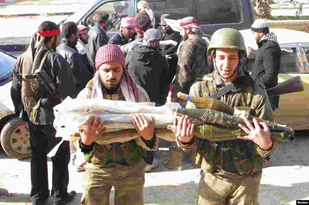 Free Syrian Army fighters transport ammunition which was seized from government forces' Wadi al-Daif military base at Maaret al-Numan,in the Idlib governorate in the northwest of Syria, December 29, 2012. 