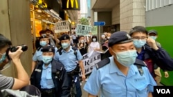 香港支聯會及社民連4名成員4月15日首個國家安全教育日遊行示威，被大批軍裝警員包圍 （美國之音湯惠芸）