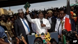 Opposition leader Raila Odinga holds up a bible during a "swearing-in" ceremony at Uhuru Park in downtown Nairobi, Kenya, Jan. 30, 2018.