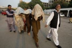 Pakistani security officials escort alleged militants of Tehreek-e-Taliban Pakistan to anti-terrorist court in Karachi, Pakistan on Thursday, Jan 5, 2012.