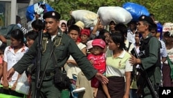 Thai police escort a group of Myanmar refugees crossing to Myawaddi town at the Thai-Myanmar border town of Mae Sot (File Photo)