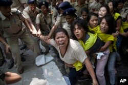 Indian policewomen detain Tibetan youth activists during a protest to highlight Chinese control over Tibet, outside the Hyderbad House in New Delhi, Sept. 18, 2014.