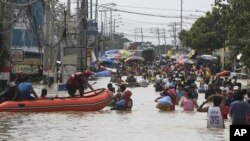 ປະຊາຊົນພາກັນຍ່າງລຸຍນໍ້າຖວ້ມ ທີ່ເກີດຈາກລົມໄຕ້ຝຸ່ນມາໄດ້ 4 ມື້
ແລ້ວໃນເມືອງ Calumpit ແຂວງ Bulacan ທາງທິດເໜືອກຸງມານີລາ.
ວັນທີ 2 ຕຸລາ 2011.