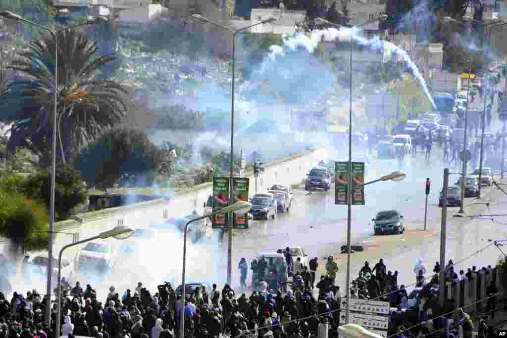 A tear gas canister flies in the air as thousands of Tunisians gathered at el Jallez cemetery to attend the funeral of slain opposition leader Chokri Belaid, Feb. 8, 2013. 