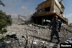 A Syrian firefighter is seen inside the destroyed Scientific Research Centre in Damascus, Syria April 14, 2018.