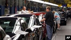 FILE - Workers put the final touches on new vehicles at General Motors' plant in Lordstown, Ohio, June 15, 2010. 