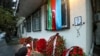 An Azerbaijan national flag, flowers and candles are seen at the wall of the apartment building in memory of a pilot Alexander Kalyanina, one of victims of the Azerbaijan Airlines crash near the Kazakhstan's airport of Aktau, in Baku, Dec. 28, 2024. 