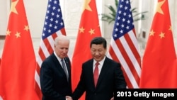 FILE - In this Dec. 4, 2013, file photo, Chinese President Xi Jinping, right, shakes hands with then U.S Vice President Joe Biden as they pose for photos at the Great Hall of the People in Beijing.