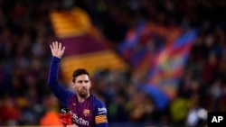 Penyerang Barcelona Lionel Messi melambai ke arah penonton saat ia memegang trofi pemain terbaik La Liga Spanyol sebelum pertandingan sepak bola antara FC Barcelona dan Atletico Madrid. (Foto: AP)