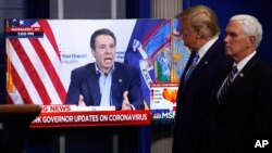 Vice President Mike Pence, right, and President Donald Trump watch a video of New York Gov. Andrew Cuomo speaking during a coronavirus task force briefing at the White House, Sunday, April 19, 2020, in Washington. 