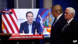 Vice President Mike Pence, right, and President Donald Trump watch a video of New York Gov. Andrew Cuomo speaking during a coronavirus task force briefing at the White House, Sunday, April 19, 2020, in Washington. 