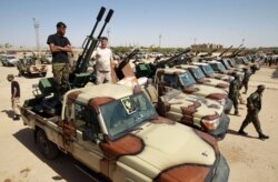 FILE - Members of the Libyan National Army gather in the city of Benghazi, on their way to back up fellow LNA fighters on the frontline west of Sirte, facing forces loyal to the U.N.-recognized Government of National Accord, on June 18, 2020.