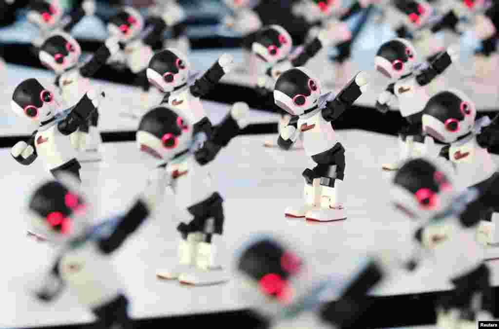 A hundred humanoid communication robots called Robi perform a dance during a promotional event called 100 Robi, for the weekly Robi magazine, in Tokyo, Japan.