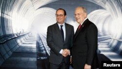 Swiss Federal President Johann Schneider-Ammann, right, speaks with French President Francois Hollande, left, on the opening day of the Gotthard rail tunnel, the longest tunnel in the world, at the fairground Rynaecht at the northern portal in Erstfeld, S
