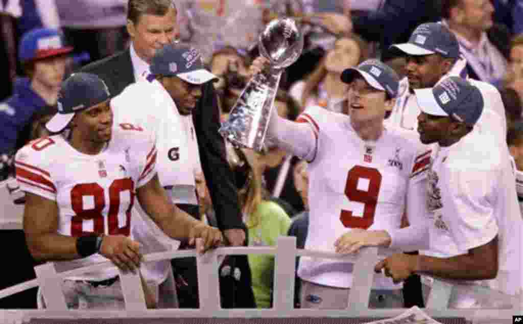 New York Giants kicker Lawrence Tynes (9) holds the Vince Lombardi Trophy after the NFL Super Bowl XLVI football game against the New England Patriots, Sunday, Feb. 5, 2012, in Indianapolis. The Giants won 21-17. (AP Photo/Charlie Riedel)