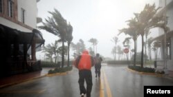 Warga berjalan sepanjang South Beach saat Badai Irma tiba di Florida selatan di Miami Beach, Florida, 10 September 2017.