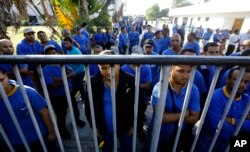 Goodyear workers arrive to find their plant is no longer in operation, in Los Guayabos, Venezuela, Dec. 10, 2018.