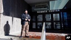Un guardia de seguridad vigila la entrada al Centro de Ciencias de Harvard, uno de los edificios evacuados por amenaza de bomba.