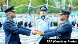 سبدوش ہونے والے ایئر چیف سہیل امان نئے ایئر چیف مجاہد انور خان کو علامتی شمشیر سونپ رہے ہیں