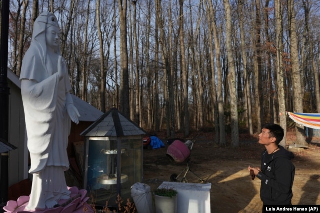 Daniel Choi stands in front of a statue of Kuan Yin, the Buddhist goddess of compassion, at the New Jersey Buddhist Vihara and Meditation Center in Franklin Township, N.J. on Tuesday, Nov. 12, 2024. (AP photo/Luis Andres Henao)