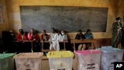 Election observers sit at a polling station for Kenya's general election in Eldoret, Kenya, Tuesday Aug. 9, 2022. 