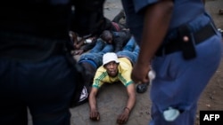 Un homme est arrêté par des membres de la police métropolitaine d'Ekurhuleni dans la banlieue de Katlehong, à Johannesburg, lors d'actes de violence anti-étrangers, le 5 septembre 2019.