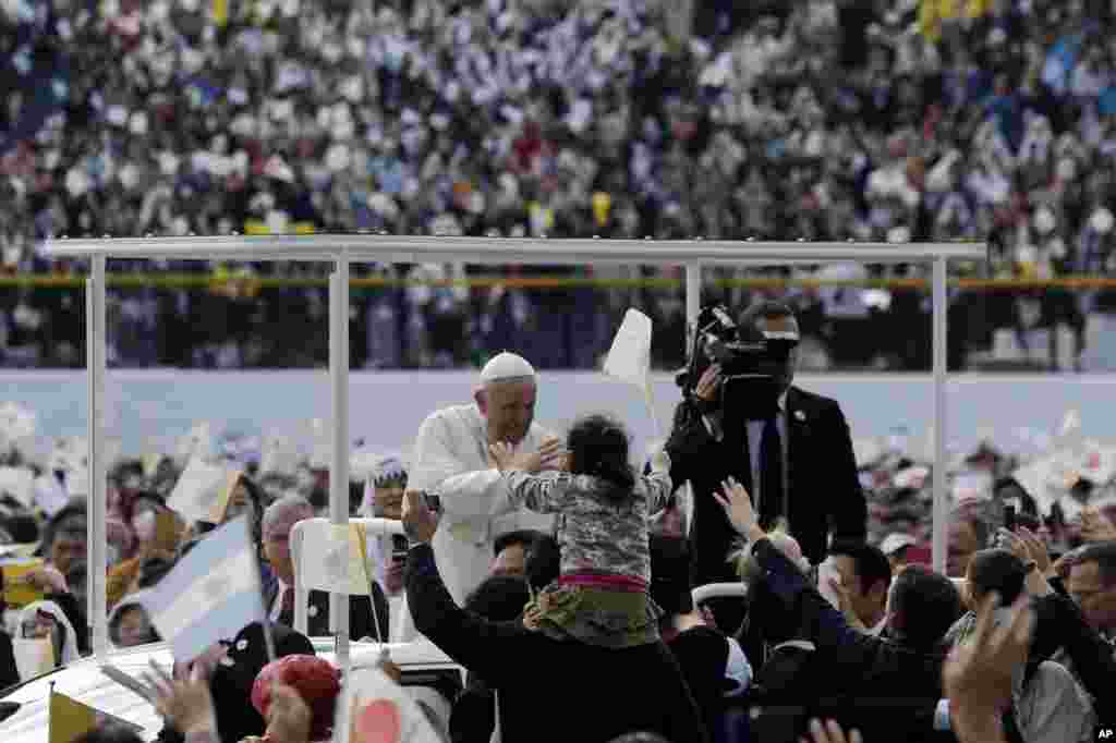 El Papa Francisco saluda desde su papamóvil donde celebró una misa en el estadio de béisbol de la prefectura de Nagasaki, el domingo 24 de noviembre de 2019, en Nagasaki, Japón. (Foto AP / Kiichiro Sato).
