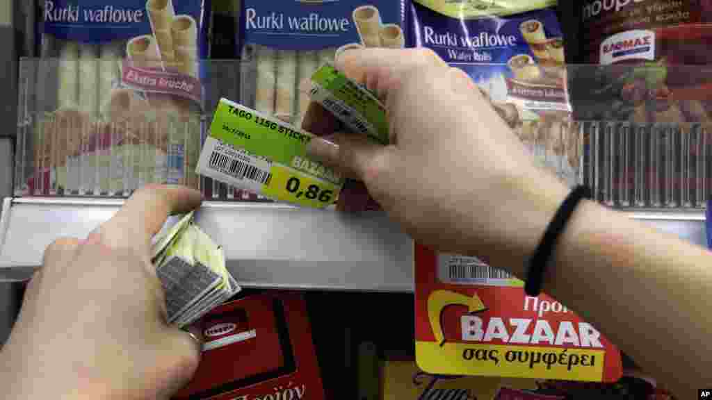 Un employé d'un supermarché remplace les prix avec la nouvelle taxe sur la valeur ajoutée, Athènes, 20 Juillet 2015.